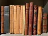 de nombreux livres anciens rangés sur une étagère d'une bibliothèque