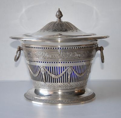 a silver bowl with a lid on a table