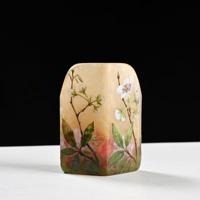 un petit vase orné de fleurs, posé sur une table