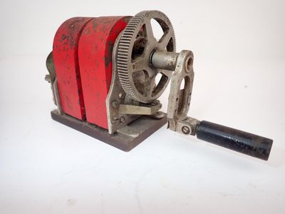 une machine rouge et noire posée sur une surface blanche