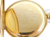 a close up of a gold pocket watch on a white surface