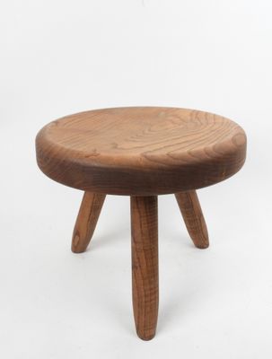 une image représentant un petit tabouret en bois posé sur une surface blanche