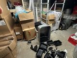 a pile of electronic equipment in a room with a lot of boxes