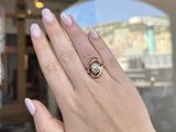 woman ' s hand with pink manicured nails holding a diamond ring