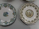 three plates with floral designs are sitting on a table
