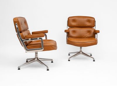 an image of a pair of brown leather office chairs on casteors