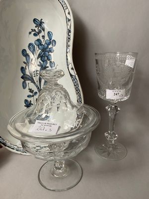 a glass bowl with a lid and a wine glass on a table