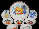 six bowls and a plate with fruit designs on them