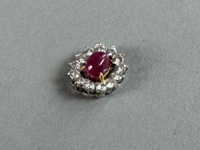 a close up of a ruby and diamond ring on a table