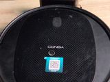 une enceinte noire posée sur une table en bois