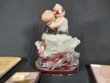 a figurine of two people sitting on a tree stump