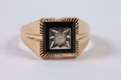 an image of a gold ring with a black and white diamond