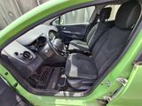 the interior of a small green car with the door open