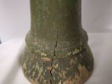 a green vase sitting on a table with a white table cloth
