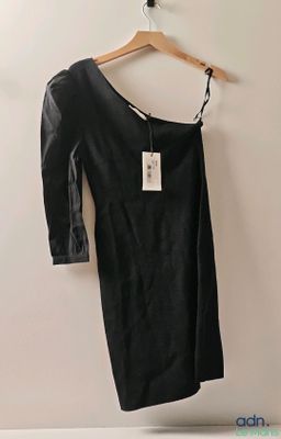 La robe noire est suspendue à un cintre accroché au mur.