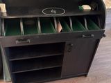 a black cabinet with green drawers and a green wallpaper
