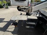a truck that is parked in a lot with a table on it