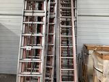 many ladders stacked up in a warehouse area