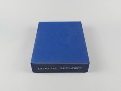 un livre bleu posé sur une table blanche