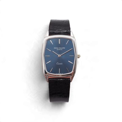 une montre posée sur une surface blanche