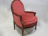 une vieille chaise avec une assise rembourrée rouge et un cadre en bois