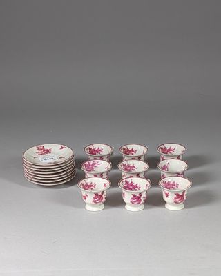 several cups and saucers with pink flowers on them on a table