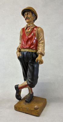 statue of a man wearing a hat and a red vest