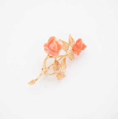 broche en forme de fleur plaquée or, ornée de fleurs roses sur fond blanc