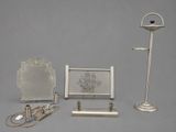three silver objects that are on display on a gray surface