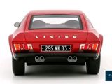 the back end of a red car on a white surface