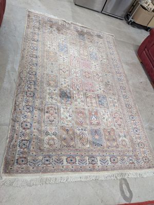 un tapis posé à même le sol dans une pièce où se trouve un canapé rouge