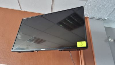 a flat screen tv hanging on a wall in a room