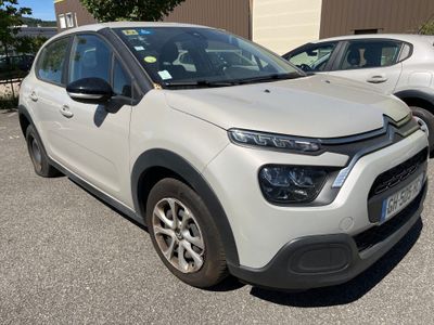La Citroën blanche est garée sur un parking, à côté d'autres voitures