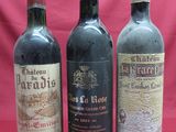 three bottles of wine are lined up on a red background