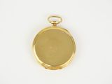 a close up of a gold plated pocket watch on a white surface