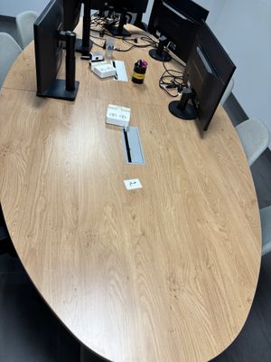 une table en bois sur laquelle sont posés deux écrans d'ordinateur