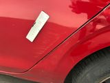 a red car that has a white button on the side of it