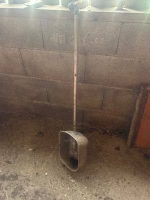 a shovel that is leaning against a wall next to a toilet