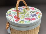 a wicker basket with a handle on a table