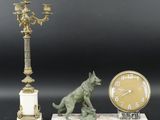 une statue représentant un chien et une horloge posée sur une table