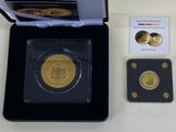 une pièce d'or dans une boîte noire, avec une carte à côté