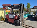 un chariot élévateur garé sur un parking à côté d'autres véhicules