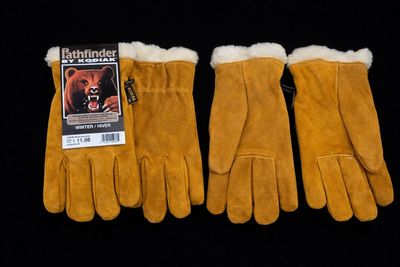 trois paires de gants en cuir marron sur fond noir
