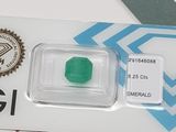 a green emerald in a clear plastic container on a table