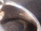 a close up of a silver ring on a black surface