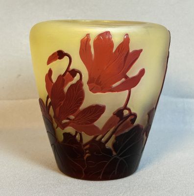 un vase orné d'une fleur rouge sur un fond blanc