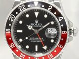 une montre Rolex avec une lunette rouge et noire