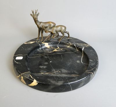 statue of a deer on a marble plate on a white surface