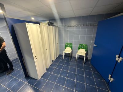 a man that is standing in a bathroom next to a urinal