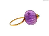 un gros plan d'une bague ornée d'une perle violette